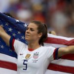 uswnt player kelley o'hara poses with an american flag at the world cup