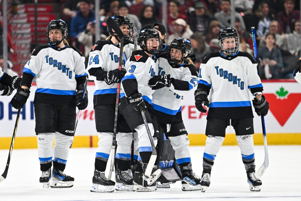 pwhl toronto hockey team celebrate a goal on the ice.