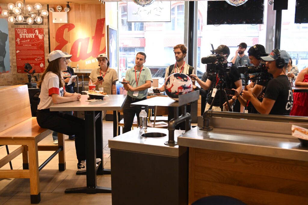 Olympic gold medalist and USWNT star Tierna Davidson speaks to reporters at a New York Raising Cane's restaurant