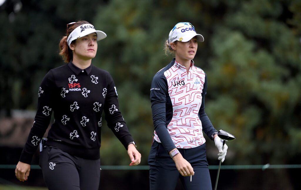 Australian golf star Hannah Green and US standout Nelly Korda walk across the green together after teeing off at a 2022 tournament.