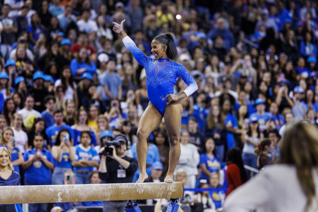 UCLA gymnastics star Jordan Chiles poses during her balance beam routine at a 2025 NCAA meet.