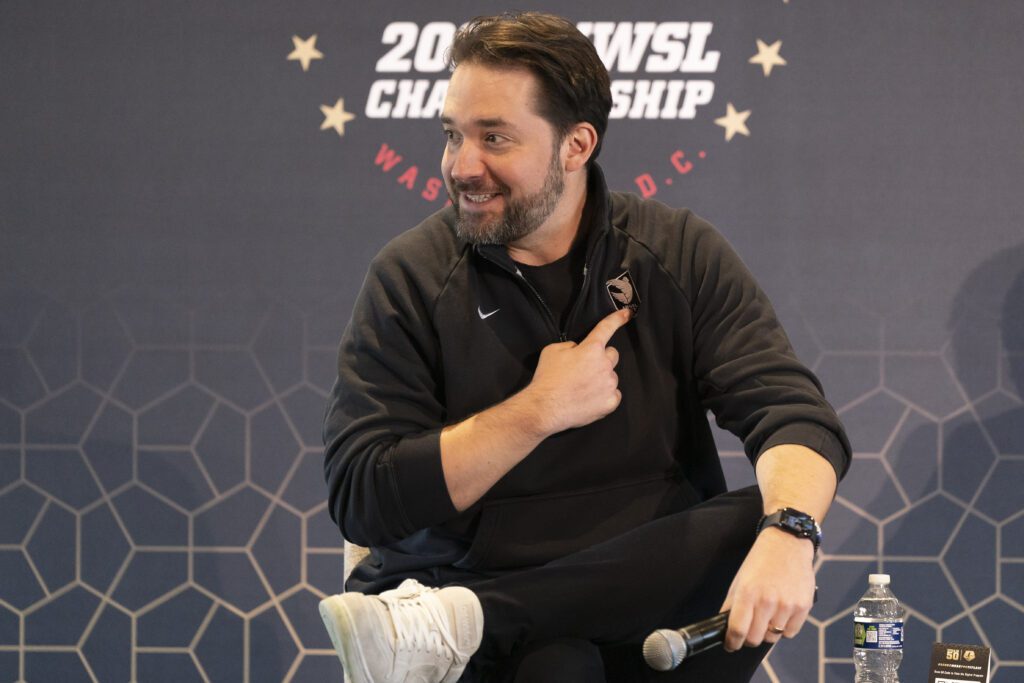 Angel City lead founding investor Alexis Ohanian points to the team crest on his jacket during a 2022 NWSL event.