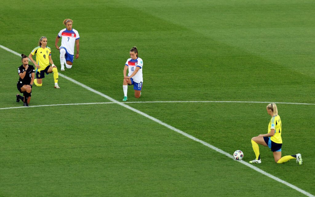 England and Sweden players, as well as the referee, take a knee to protest racism before a 2025 Euro quarterfinal match.
