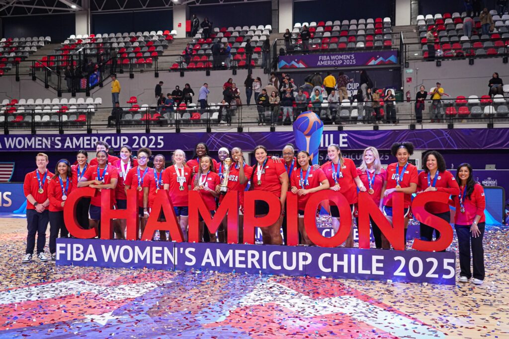 The USA Basketball team and coaching staff pose with a 2025 FIBA AmeriCup Champions sign after winning gold.