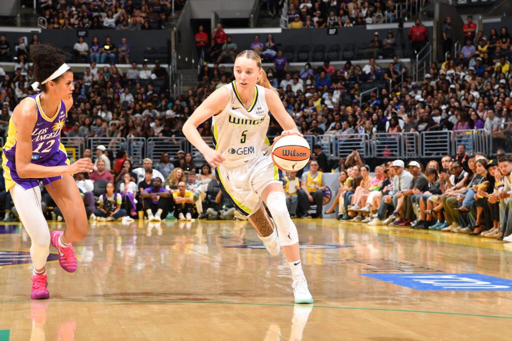 LA Sparks guard Rae Burrell gives chase as Dallas Wings rookie Paige Bueckers drives to the basket during a 2025 WNBA game.