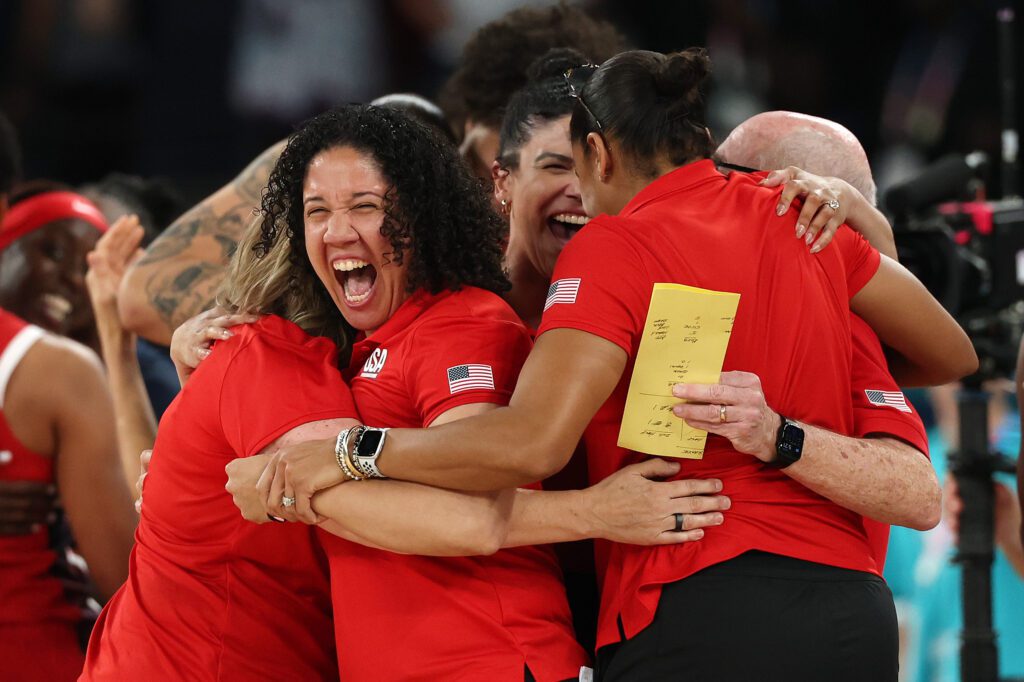 Assistant coach Kara Lawson and the Team USA coaching staff hug in celebration of their gold-medal win at the 2024 Olympics.