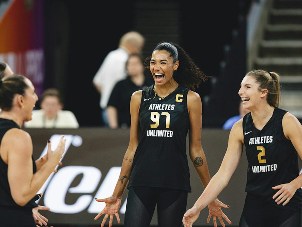 Opposite Jordan Thompson and setter Sydney Hilley celebrate a play with their Athletes Unlimited volleyball teammates during a 2025 game.