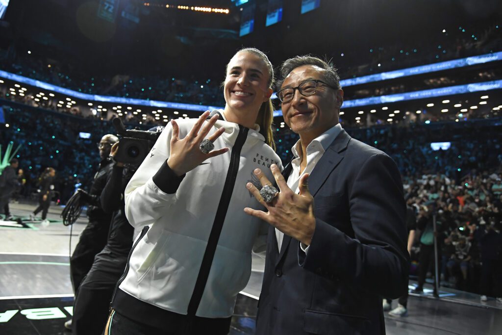 New York star Sabrina Ionescu poses with Liberty owner Joe Tsai wearing their 2024 WNBA Championship rings.