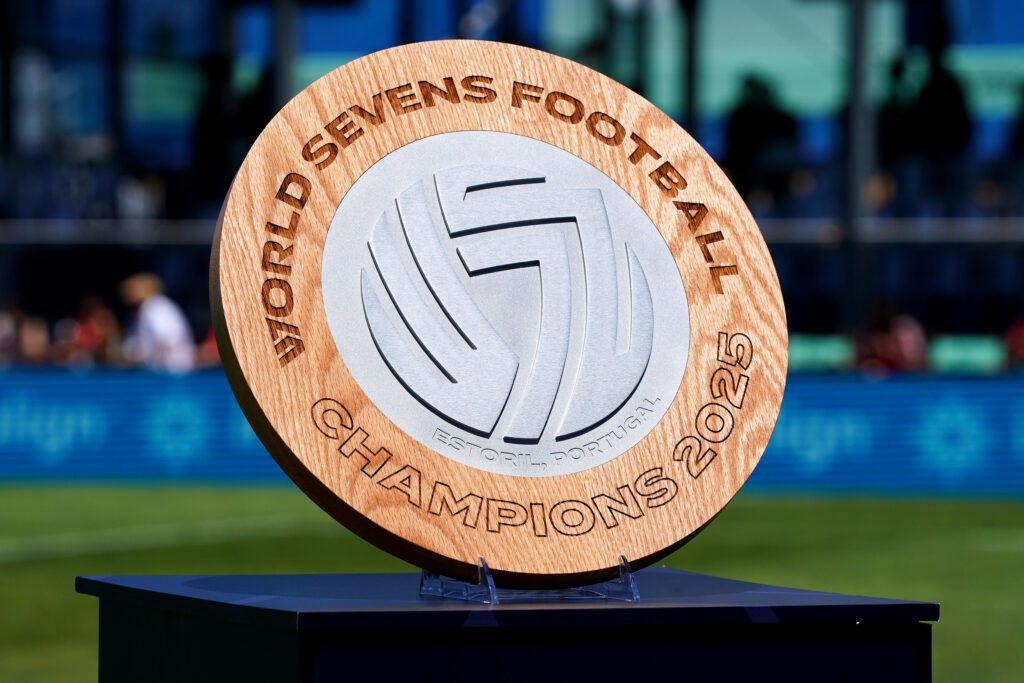 The World Sevens Football trophy is displayed next to the pitch before the inaugural W7F tournament final in May 2025.