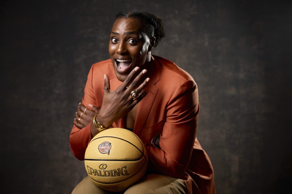 Retired WNBA star Sylvia Fowles poses in her Naismith Hall of Fame jacket and ring holding a basketball during her 2025 induction.