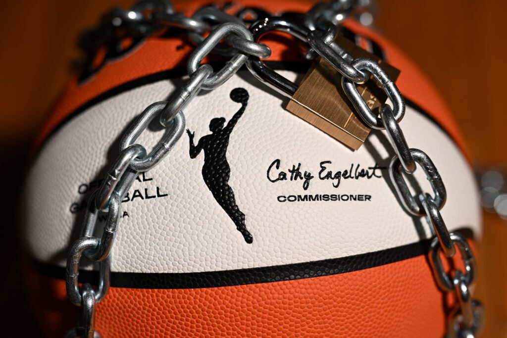 An official WNBA basketball sits with a lock and chain around it to warn of a potential league lockout without a new CBA.