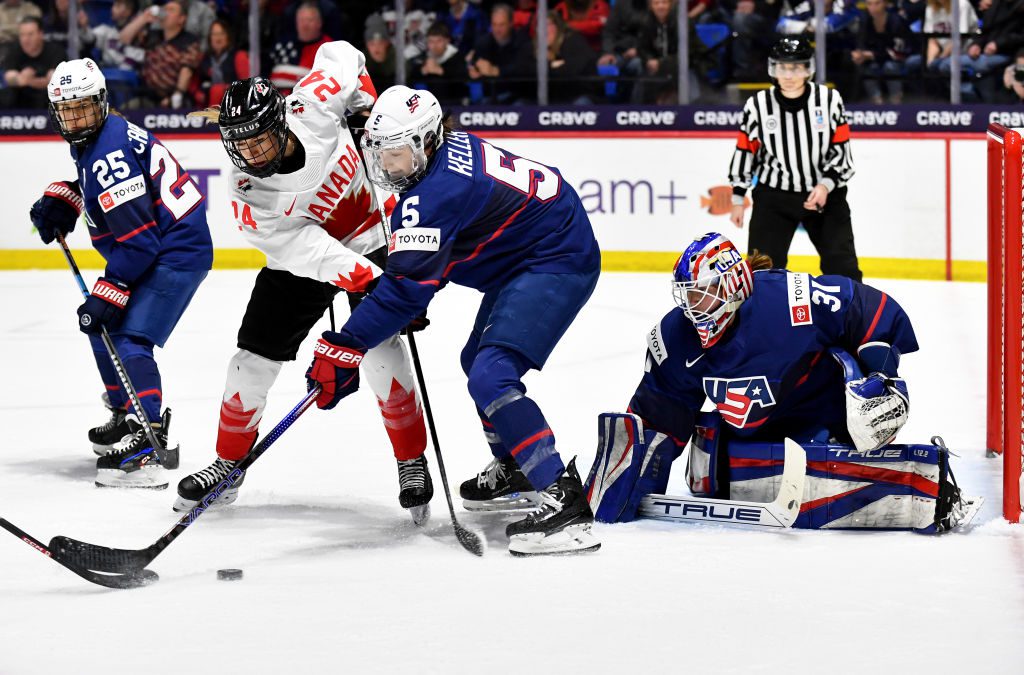 Megan Keller #5 of United States defends against Natalie Spooner #24 of Canada as she tries to deflect the puck past Aerin Frankel #31 of United States in the 1p during the 2024 IIHF Women's World Championship Gold Medal game at Adirondack Bank Center on April 14, 2024 in Utica, New York.