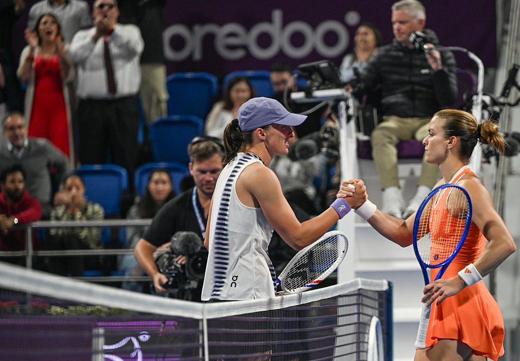 Iga Swiatek of Poland shakes hand with Maria Sakkari of Greece at the end of their quarterfinal match on Day Five of the Qatar TotalEnergies Open, part of the Hologic WTA Tour, at the Khalifa International Tennis and Squash Complex on February 12, 2026 in Doha, Qatar.