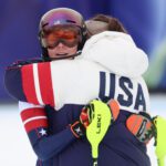 USA ski star Mikaela Shiffrin hugs a teammate after a disappointing slalom run in the women's team combined at the 2026 Winter Olympics.