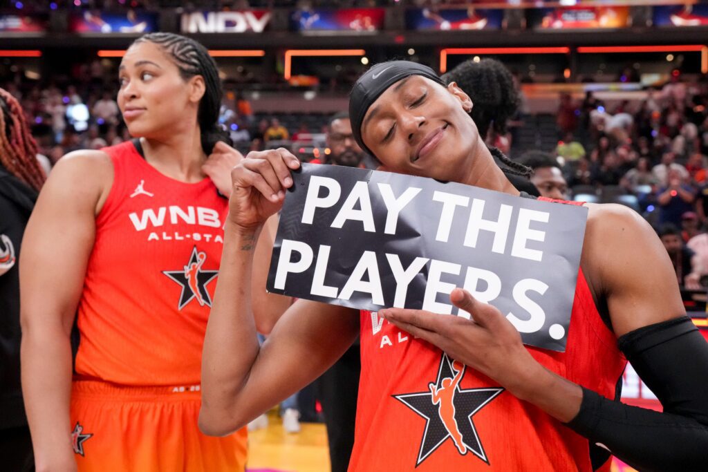 WNBA CBA negotiator Brittney Sykes holds a sign that says "Pay the Players" during the 2025 WNBA All-Star Game.